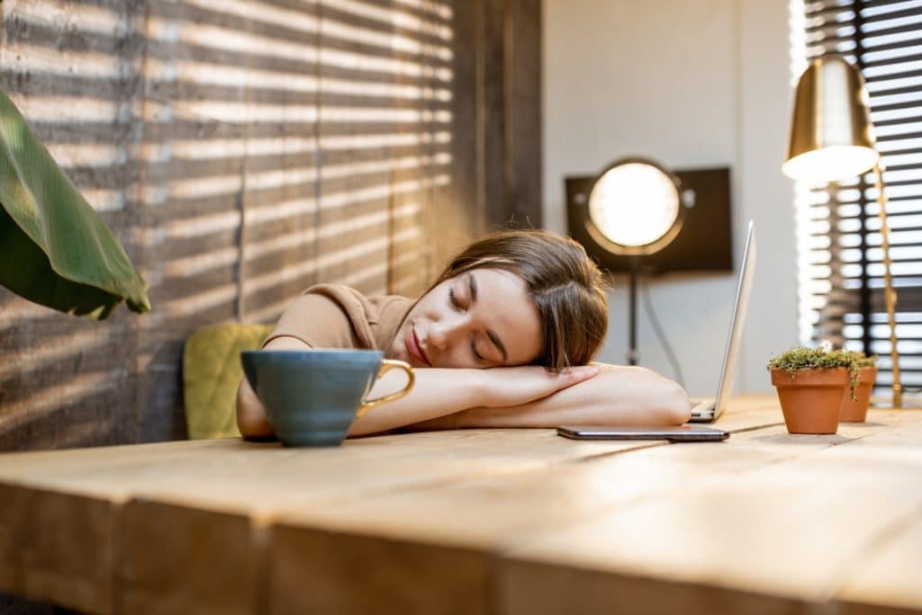 Sleepy woman at the workplace at home