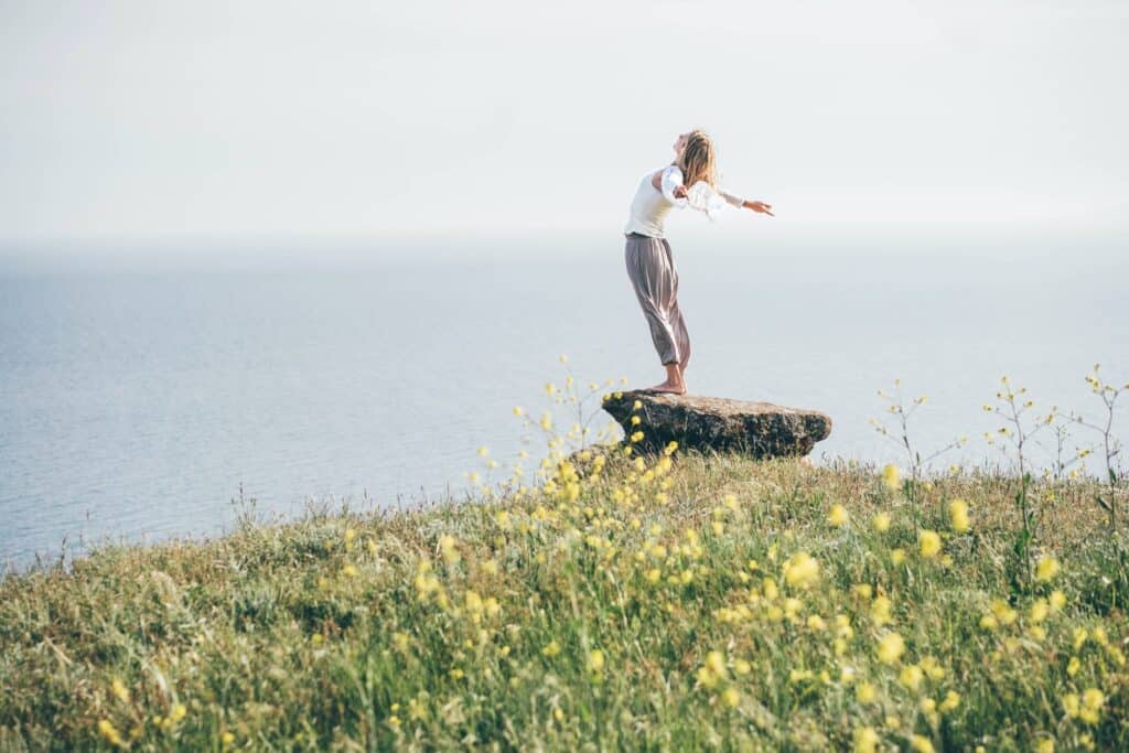 Woman taking a breath on a majestic mountain and sea.